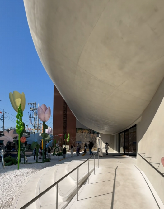 บริเวณทางเข้า Gentle Monster ย่าน Apgujeong กรุงโซล แสดงพื้นที่ใต้ชายคา ทางลาด และงานอินสตอลเลชันด้านนอกอาคาร