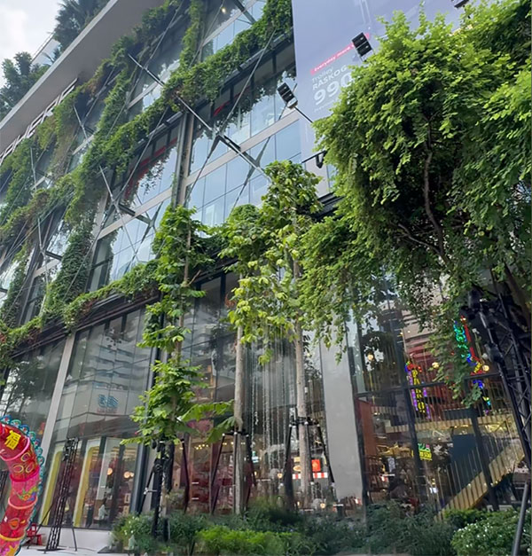 ภาพภายนอกอาคารและป้ายแบรนด์ของ EmSphere แสดงการรับรู้อาคารจากภายนอกและการจัดการพื้นที่สีเขียวบนฟาซาด