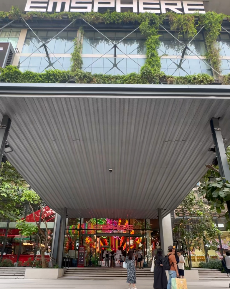 ภาพทางเข้าหลักและชายคา cantilever ขนาดใหญ่ของ EmSphere แสดงพื้นที่ร่มเงาและพื้นที่ก่อนเข้าสู่อาคาร