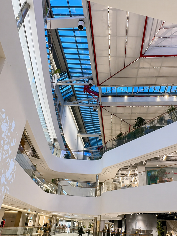 ระบบ skylight และโครงสร้างหลังคาของ The Hyundai Seoul ที่เห็นการรับแสงขนาดใหญ่ โครงสร้างด้านบน และความสัมพันธ์ของพื้นที่หลายชั้น